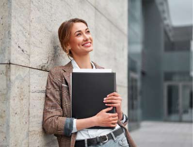 Kobieta z teczką elegancko ubrana symbolizująca pracowników korporacji którzy potrzebują ergonomicznego mieszkania i oszczędności czasu